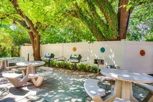 un grupo de mesas de picnic y sillas en un patio en Comfy & Relaxing Apt, en Alexandria