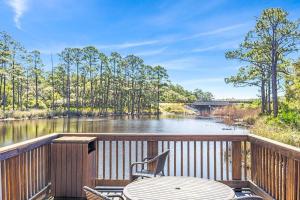 a deck with a table and chairs and a river at Redfish Village - Beach-a-holic - M1-313 in Santa Rosa Beach