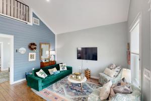 a living room with a green couch and a table at Modern Steps to Beach Shared Pool & Playground in Caplen