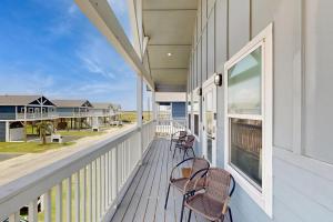 a porch with two chairs and a view of the ocean at Modern Steps to Beach Shared Pool & Playground in Caplen