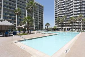 Una gran piscina con palmeras y edificios. en Sweeping 10th Floor Views Up to 10 Beachfront, en South Padre Island