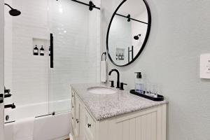 a bathroom with a sink and a mirror at Modern Steps to Beach Shared Pool & Playground in Caplen +17 photos