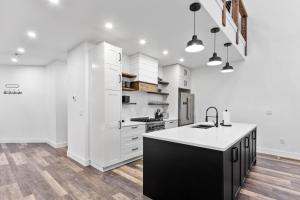 a kitchen with white cabinets and a black island at Alpine Glow Ski Haus in Whitefish