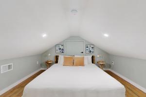 a bedroom with a large white bed with two side tables at Modern Steps to Beach Shared Pool & Playground in Caplen