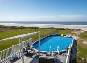 a swimming pool on a deck next to the beach at Ocean Paradise 5BR Beach Escape Hot Tub Game Room and Firepit in Gilchrist