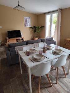 une table blanche et des chaises dans un salon dans l'établissement Petite maison de charme, à LʼIsle-sur-la-Sorgue