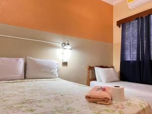 a bedroom with two beds with towels and a window at Hotel Hernandez in Chiquimula