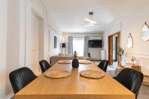 a dining room with a wooden table and chairs at Elegant 3 Bdr Apartment City Retreat in Kypseli in Mesochórion