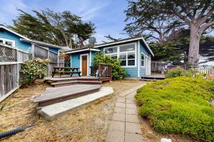 una casa azul con un banco delante en Headlands Cove - Retreat, en Mendocino