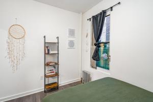 a bedroom with a green bed and a window at Oasis Apartment by Columbus Circle & Times Square in Manhattan in New York