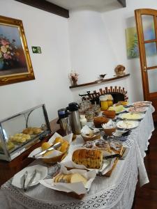 a long table with bread and other food on it at Pousada dos Pássaros in Camanducaia