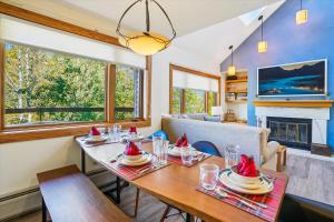une salle à manger avec une table et une cheminée dans l'établissement Cozy 2BR Highridge Condo Unit I3 in Killington, VT with hot tub and scenic woods view., à Killington Village