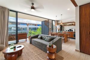 een woonkamer met een bank en een tafel bij Tropical 2 Bedroom | Private Balcony & Rooftop | Casago in Tulum
