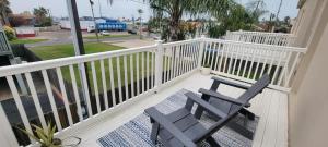 un porche con 2 sillas azules en el balcón en 2 levels Big 3 bedroom Near Beach Pool, en South Padre Island