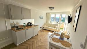 a kitchen with a sink and a table in a room at Cosy Studio Gdynia Kamienna Góra in Gdynia