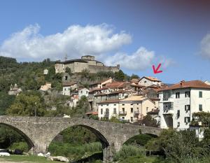 a bridge over a river with a town in the background at La Casa del Voltone in Pontremoli