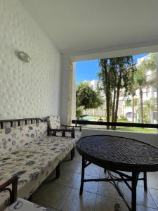 a room with a couch and a table and a window at Olivier Asilah Golf Piscines in Asilah