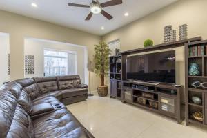 a living room with a leather couch and a flat screen tv at Big Private Luxury Home in Beach Gated Community in South Padre Island