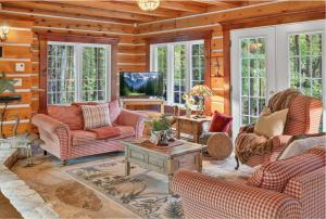 un salon avec des canapés et une télévision dans l'établissement Domaine Rivière Sacacomie - Chalet Le Huard, à Saint-Alexis-des-Monts