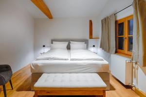 - une chambre avec un lit et un banc dans l'établissement Stube & Stories - Heritage Riverside Home, à Garmisch-Partenkirchen