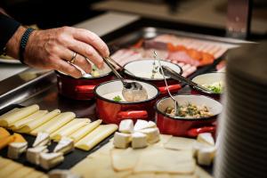 eine Person, die Essen in Töpfen auf einem Grill zubereitet in der Unterkunft Corso Hotel Pécs in Pécs + 53 Fotos