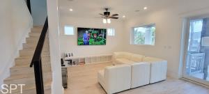 Una sala de estar con un sofá y un ventilador de techo. en Luxury Remodel Sleeps 20 Pool Go VIP, en South Padre Island