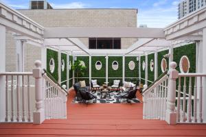une terrasse avec des chaises et des tables dans un bâtiment dans l'établissement Iconic 9BR Landmark in Gaslamp Sleeps 14, à San Diego