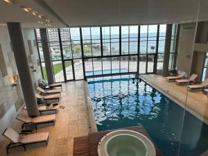 a large swimming pool with lounge chairs in a building at Clara Suite in Mar del Plata