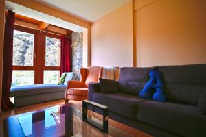 a living room with a blue teddy bear sitting on a couch at A 2 min de Grandvalira I Ski, Vistas, Wifi y Parking I Aliga in Soldeu