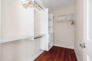 a walk in closet with white cabinets and wood floors at Share Home- Cozy Getaway in Vancouver in Vancouver +8 photos