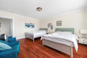 a bedroom with two beds and a blue couch at Share Home- Cozy Getaway in Vancouver in Vancouver