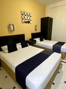 a hotel room with two beds with blue and white sheets at HOTEL IMPALA DE TAMPICO in Tampico