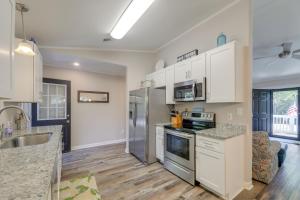 a kitchen with white cabinets and a stainless steel refrigerator at Lovely Emerald Isle Home, Walk to Beach! in Emerald Isle