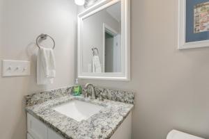 a bathroom with a sink and a mirror at Lovely Emerald Isle Home, Walk to Beach! in Emerald Isle +25 photos