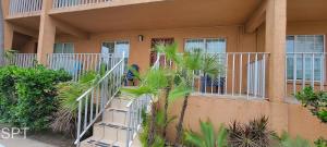 a building with stairs and palm trees in front of it at Max Walkable Location 1st Floor 2 Patios in South Padre Island +68 photos
