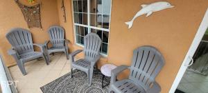 a porch with three chairs and a dolphin on the wall at Max Walkable Location 1st Floor 2 Patios in South Padre Island