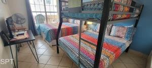 a bedroom with two bunk beds with a couch at Max Walkable Location 1st Floor 2 Patios in South Padre Island