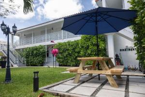 einem Picknicktisch mit einem Regenschirm vor einem Gebäude in der Unterkunft B07 5 min from beach studio in Miami