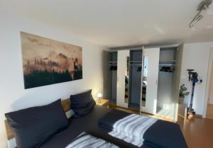 a bedroom with a bed and a large painting on the wall at Rückzugsort im Buhlbachtal Baiersbronn - Ferienwohnung mit beheiztem Wintergarten, Bergblick & Parkplatz in Baiersbronn