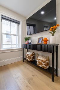 ボストンにある3BR3Bth Entire House Steps to Downtown & TD Gardenの黒い棚と窓のあるリビングルーム