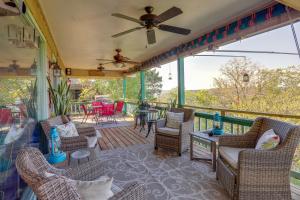 a screened in porch with chairs and a ceiling fan at The Treehouse in Cherokee Village Deck and Views in Hardy
