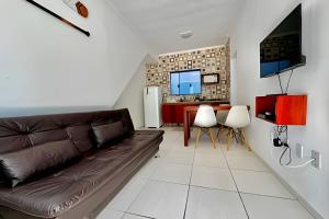 a living room with a brown couch and a table at Apartamentos Recanto da Barra in Ubatuba