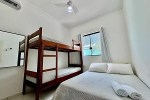 a bedroom with a bunk bed and a window at Apartamentos Recanto da Barra in Ubatuba