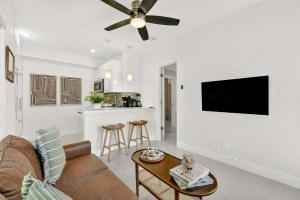 een woonkamer met een bank en een plafondventilator bij Chic Modern Studio with Queen Bed in Fort Lauderdale