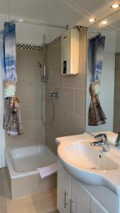 a bathroom with a sink and a shower and a tub at Lichtdurchflutetes City-Apartment im Herzen der Stadt in Neumünster