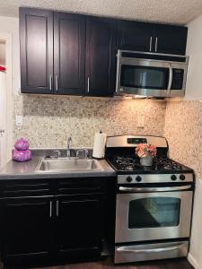 a kitchen with a stove and a sink and a microwave at The Layover Lounge in Elizabeth +13 photos