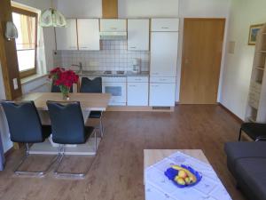eine Küche mit einem Tisch, Stühlen und einem Tisch in der Unterkunft Appartment Nill in Hippach