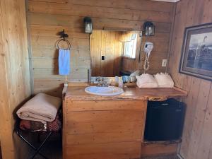 a bathroom with a sink in a wooden cabin at Chinook Winds Lodge in Dubois +122 photos