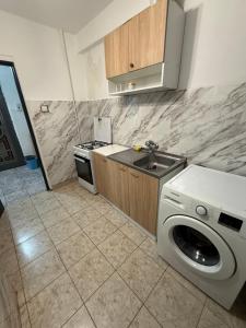 a kitchen with a washing machine and a sink at Apartament 2 camere in Craiova
