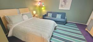 a bedroom with a bed and a blue couch at 3 bedr w-private pool 1 block to beach Pets Ok in South Padre Island